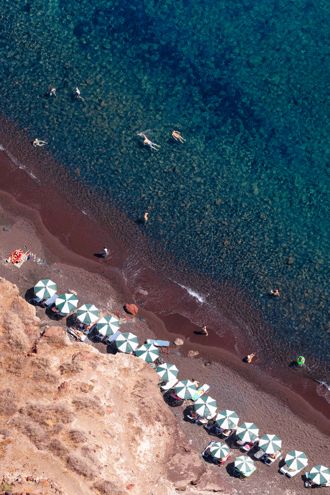 Photography by Gray Malin of Red Beach Umbrellas, Santorini
