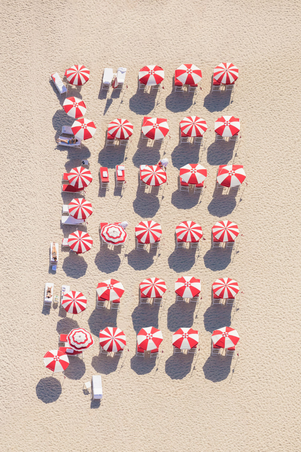 Photography by Gray Malin of Red and White Striped Beach Umbrellas