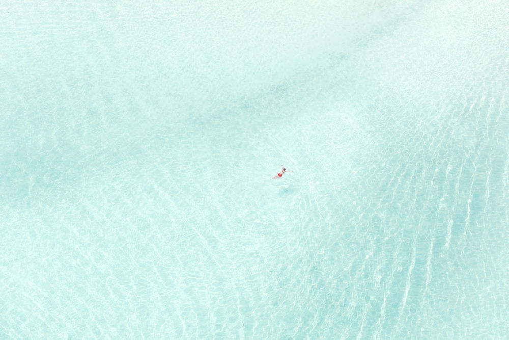 Photography by Gray Malin of Man in Red Shorts, Bora Bora