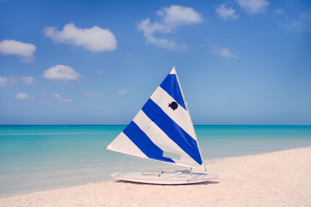 Photography by Gray Malin of Blue and White Striped Sailboat