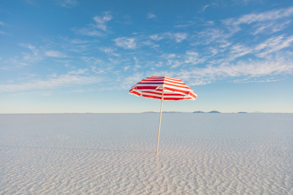 Photography by Gray Malin of Red and White Striped Umbrella
